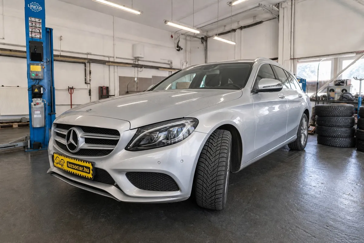 Ezüst Mercedes téli gumiabronccsal és Luzso Car rendszámtakaróval a Delato műhelyében