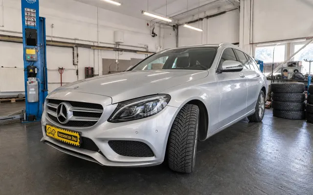 Ezüst Mercedes téli gumiabronccsal és Luzso Car rendszámtakaróval a Delato műhelyében